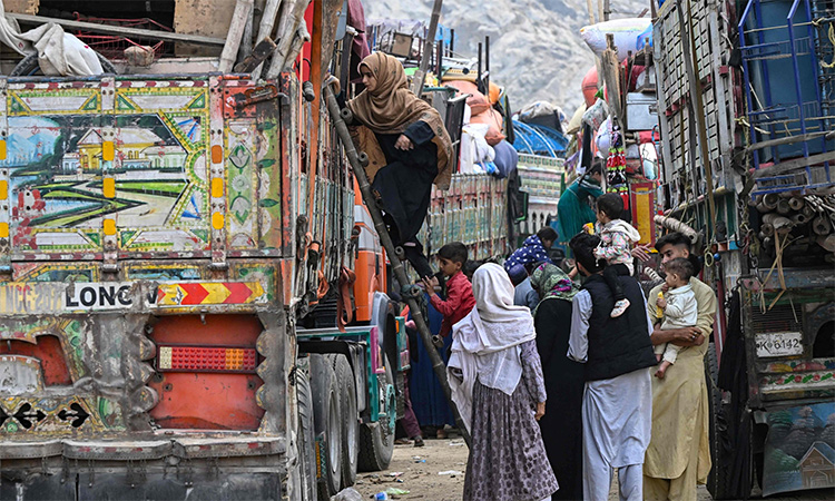 Afghan refugees climb a truck as they prepare to depart for Afghanistan, at a holding center in Landi Kotal, Pakistan. AFP