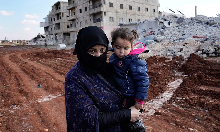 Ayesha, who lost her home in the devastating earthquake, carries her granddaughter in Atareb, Syria.  Associated Press