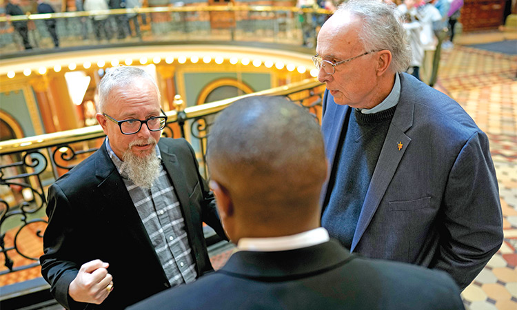 Rev. Mike Demastus, of Des Moines, Iowa, (left) and Rev. Bob Curry, of Johnston, Iowa, talk with State Rep. Eddie Andrews, centre on Thursday at the Statehouse in Des Moines, Iowa. Associated Press