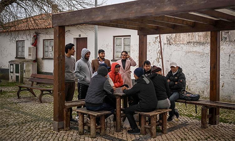 Asian immigrants gather at the end of the day at a square in Sao Teotonio, Odemira. File/AFP
