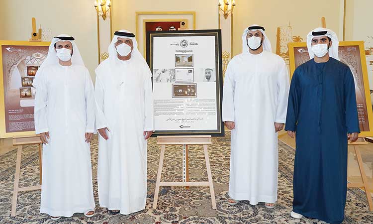 Sheikh Saud with other dignitaries during the presentation of a commemorative postage stamp .