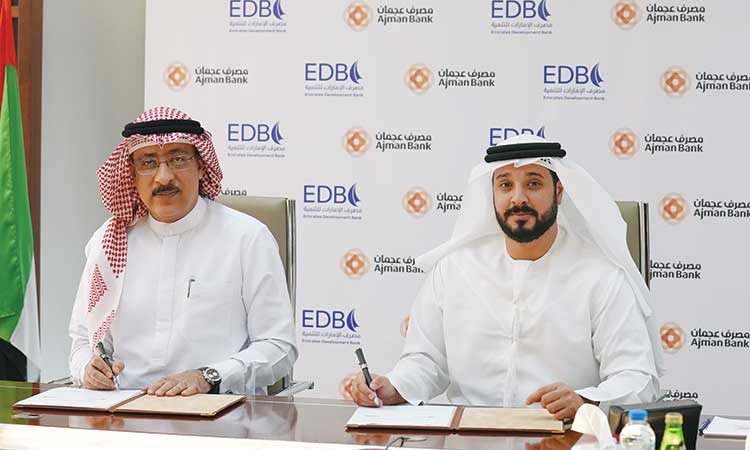 Officials of Ajman Bank and Emirates Development Bank signing the MoU.