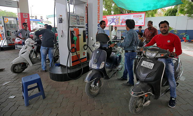 People get their two-wheelers filled with petrol at a fuel station in Ahmedabad.  Reuters