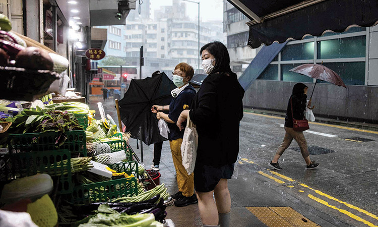 Customers shop at a vegetable stall in Hong Kong on Wednesday.  Agence France-Presse