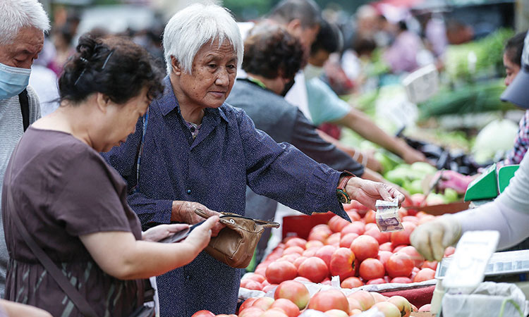 People buy vegetables at a market in Shenyang in China’s northeastern Liaoning province.   Agence France-Presse