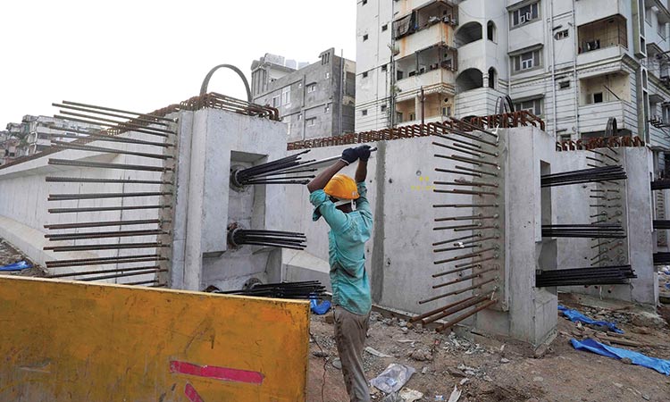 A labourer works on the construction of a flyover bridge in Hyderabad on Wednesday.  Associated Press