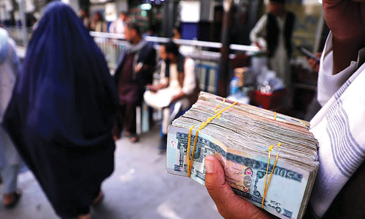 A person holds a bundle of Afghani banknotes at a money exchange market in Kabul, Afghanistan. Reuters