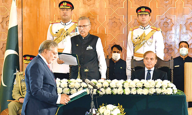President Arif Alvi (centre) administers oath of office to FM Ishaq Dar as Shahbaz Sharif watches during a ceremony in Islamabad on Wednesday.