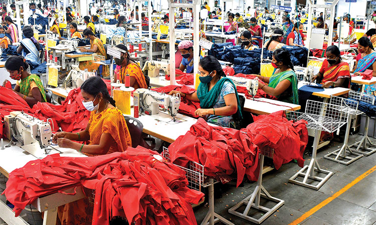 Garment workers stitch shirts at a textile factory in Hindupur town in Andhra Pradesh, India.