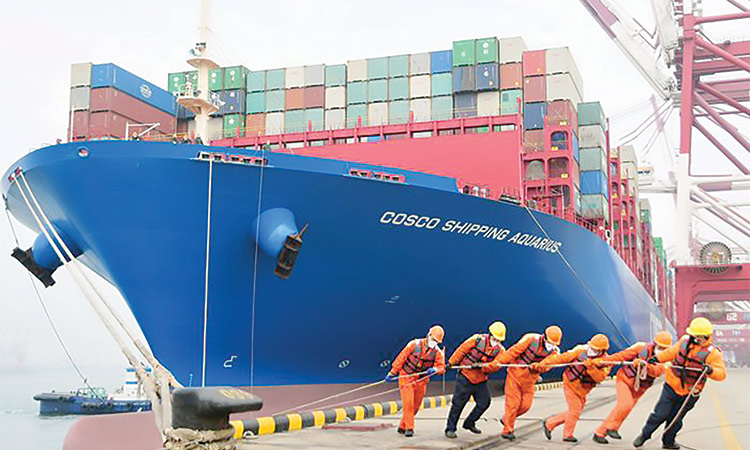 Workers roping a container ship at a port in Qingdao, Shandong province, China
