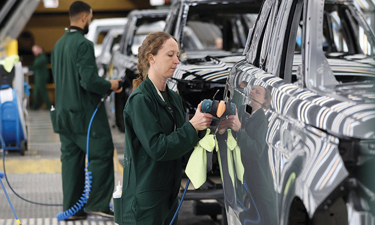 Members of staff check the paintwork on Range Rover bodies at Jaguar Land Rover’s factory in Solihull, Britain.  Reuters