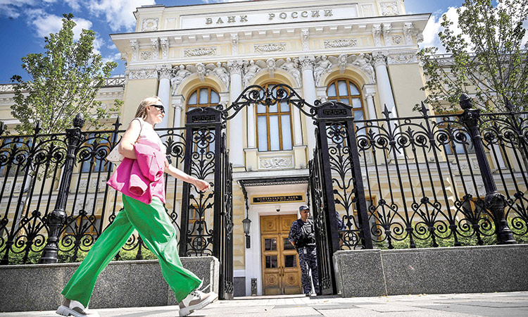 A woman walks past the Russian Central Bank headquarters in downtown Moscow on Friday. Agence France-Presse