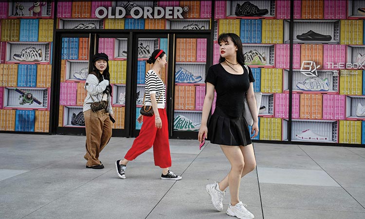 People walk outside a shopping mall in Beijing on Wednesday. Agence France-Presse