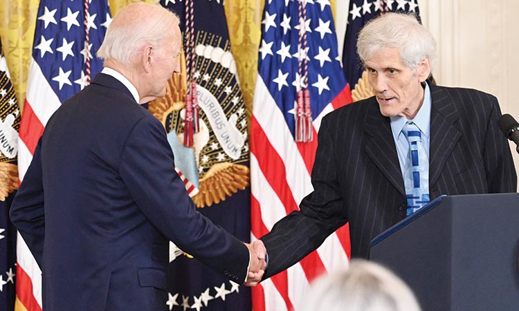 Steven Hadfield, Inflation Reduction Act beneficiary, shakes hands with US President Joe Biden prior to remarks about lowering healthcare costs in Washington on Wednesday. 