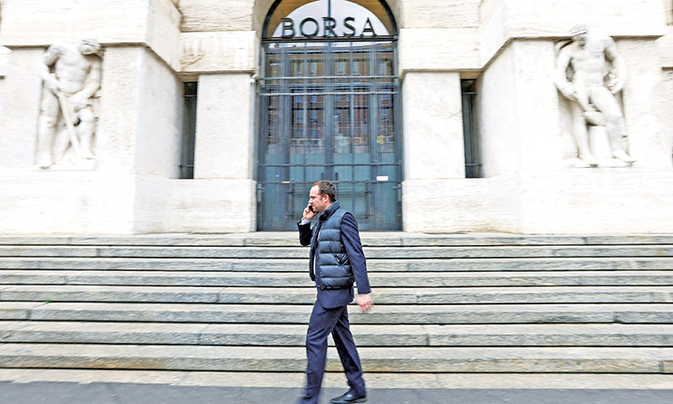 A man walks past the Milan stock exchange building in Milan, Italy.  Reuters