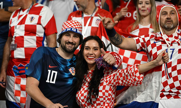 Fans of Croatia look at a mobile phone on the stands ahead of the Qatar 2022 World Cup Group F football match between Croatia and Canada at the Khalifa International Stadium in Doha on November 27, 2022. (Photo by OZAN K