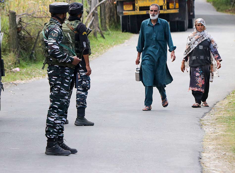 Indian soldiers stand guard as a Kashmiri family walks past the Gadole forest of Kokernag in south Kashmir's Anantnag district on Saturday.  AFP