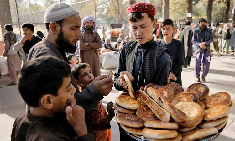 A boy sells bread at a makeshift shelter for displaced Afghan families, who are fleeing the violence in their provinces, at Shahr-e Naw park, in Kabul, Afghanistan. File/Reuters