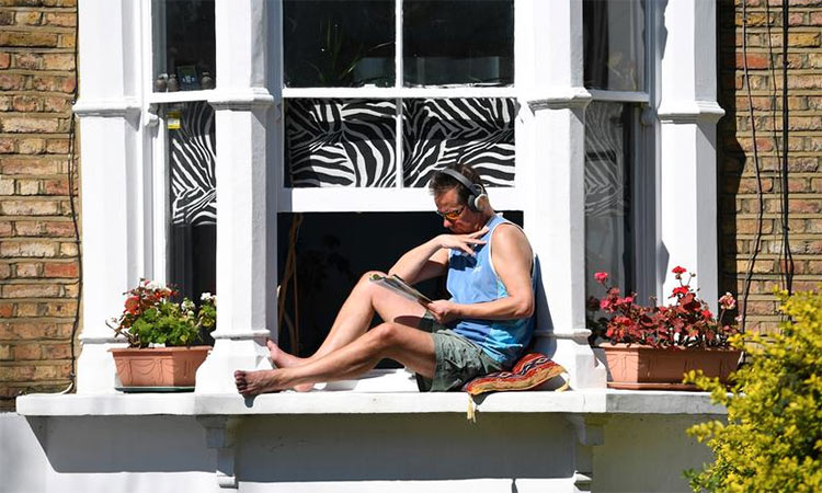 A man sits on his window sill in Islington, London, as the coronavirus disease continues to spread in Britain. (File/Reuters)