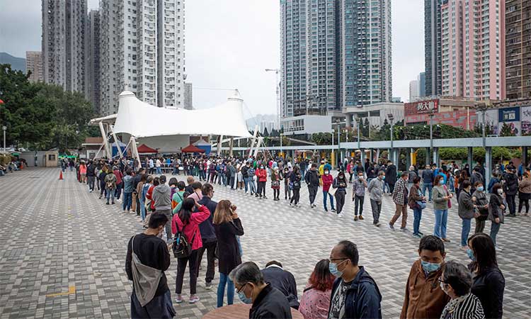 People queue outside a temporary community testing centre which provides free COVID-19 testing services in the Wong Tai Sin area of Hong Kong on Sunday.  Agence France-Presse