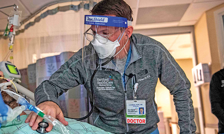 Dr. James Samuel Pope treats a patient who is suffering from the effects of COVID-19 in the ICU at Hartford Hospital in Hartford, Connecticut.