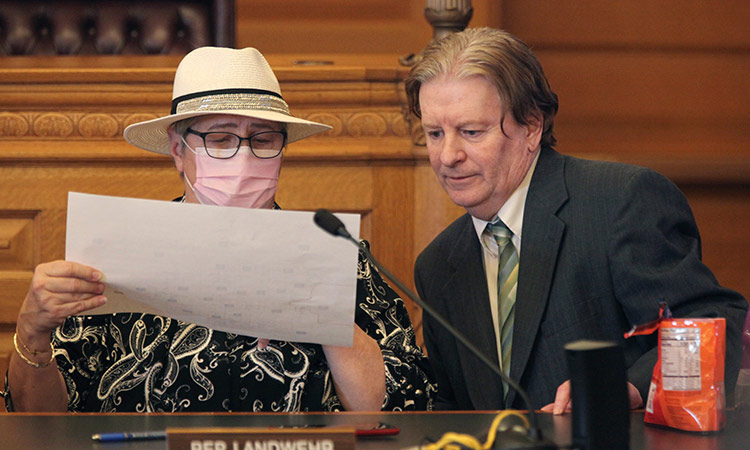 Kansas state Reps. Brenda Landwehr (left), and Steve Huebert, confer during a meeting of a House committee on redistricting at the Statehouse in Topeka, Kansas. 