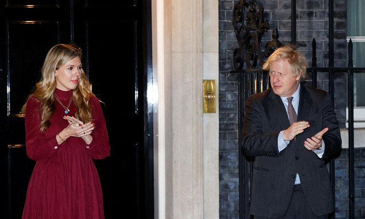 Boris Johnson and partner Carrie Symonds applaud outside 10 Downing Street during a national clap for late Captain Sir Tom Moore and NHS workers, amidst the coronavirus disease outbreak, in London, Britain.  File/Reuters