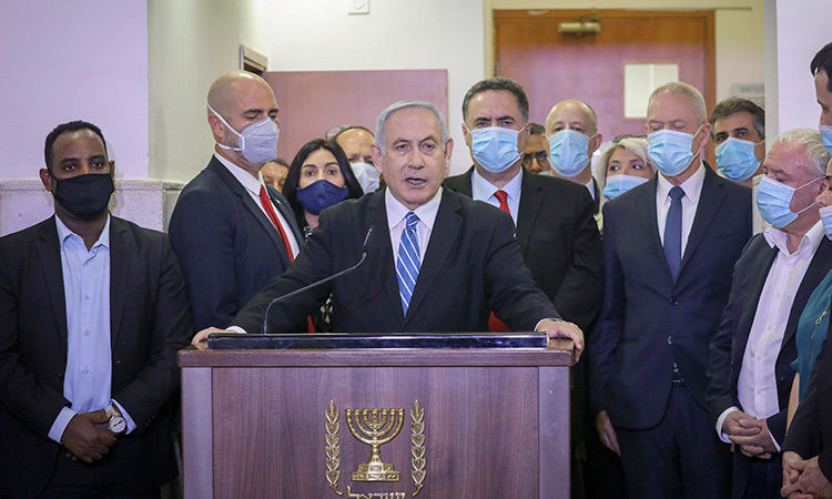 Israeli Prime Minister Benjamin Netanyahu accompanied by members of his Likud Party in masks delivers a statement before entering the district court in Jerusalem.  File/Associated Press