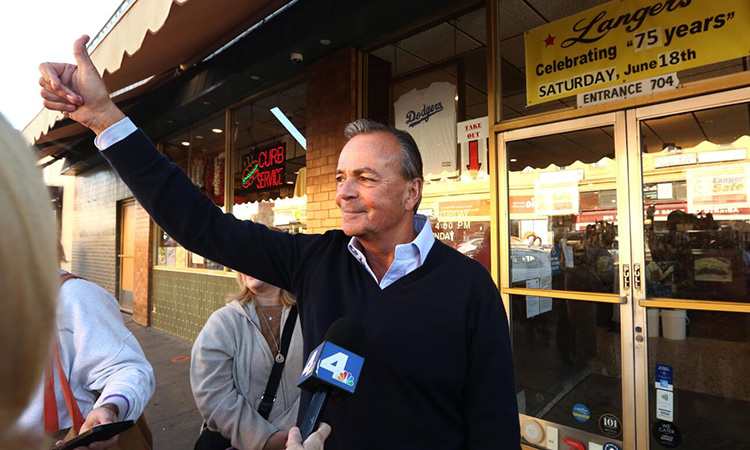 Rick Caruso gives a thumbs up as a van of supporters shouted their approval on passing while making a post election stop at Langer’s Deli in MacArthur Park in Los Angeles.  File/Tribune News Service
