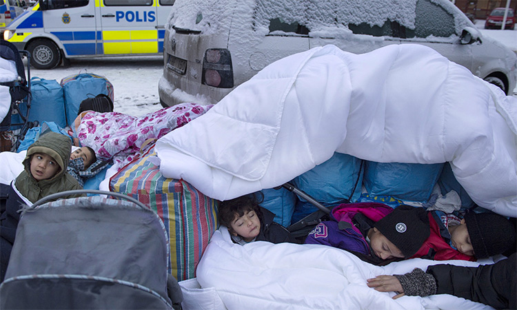 Refugees wrapped in blankets and winter clothing cross the border from the Former Yugoslav Republic of Macedonia to Serbia in freezing temperatures. 