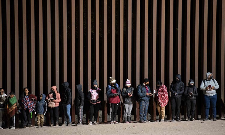 Asylum-seekers line up to be processed by US Customs and Border Patrol agents at a gap in the US-Mexico border fence near Somerton, Arizona on Monday. AFP
