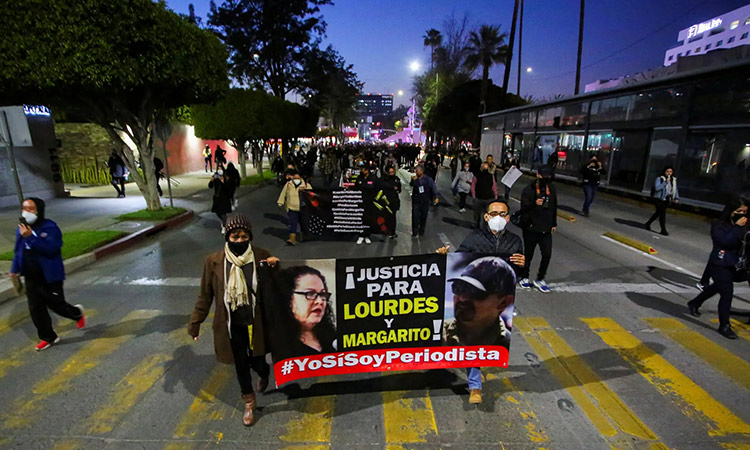 Journalists marching toward the office of the attorney general in Tijuana with a sign demanding justice. File/Reuters