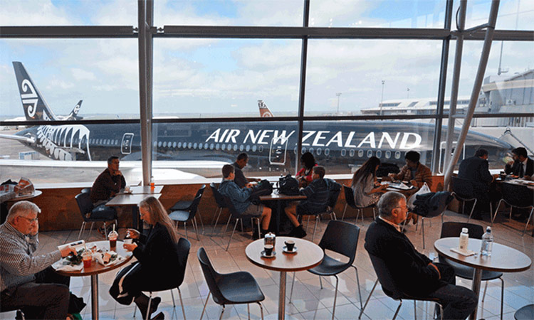 Passengers at a cafe wait for their flight to Auckland, New Zeland.