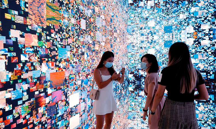 Visitors are pictured in front of an immersive art installation titled ‘Machine Hallucinations — Space: Metaverse’ by media artist Refik Anadol at the Digital Art Fair, in Hong Kong, China. File/Reuters
