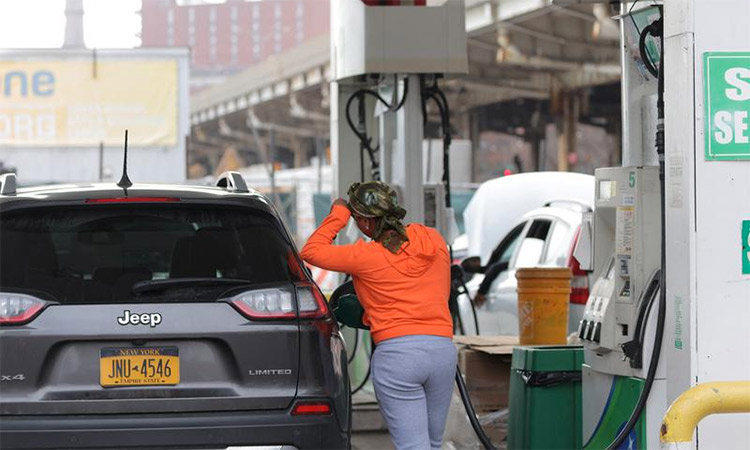 A person uses a petrol pump at a gas station as fuel prices surged in Manhattan, New York City. Reuters