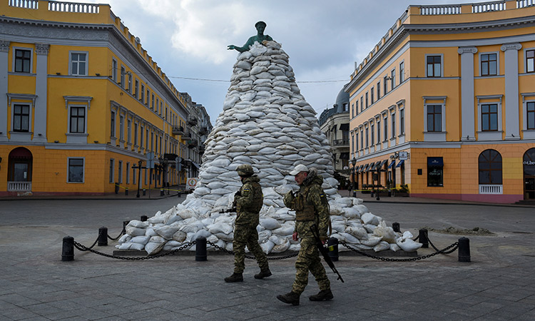 Ukrainian soldiers walk past a monument of the city founder Duke de Richelieu, covered with sand bags for protection, amid Russia’s invasion of Ukraine, in Odessa, on March 10. Reuters