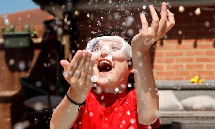 Noah, 10, cools himself off in his garden during hot weather in Hertford, Britain. Reuters