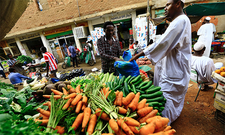 A man buys vegetables at a market in Khartoum. Reuters