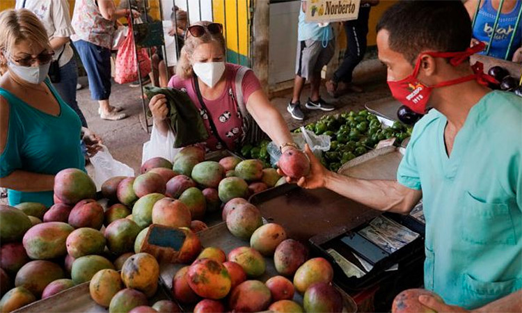 People buy mangos in a public market in Havana, Cuba. Reuters