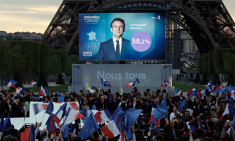 Supporters of Emmanuel Macron celebrate as a giant screen in front of the Eiffel Tower shows final results of the French presidential elections in Paris. Reuters