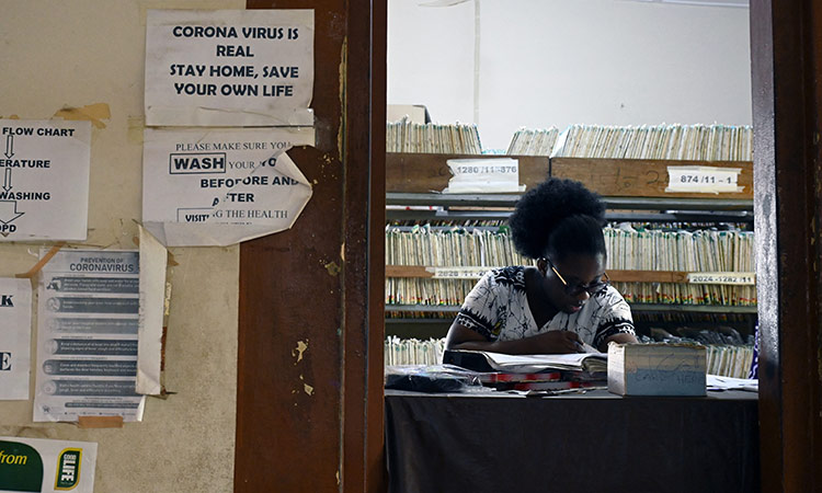 A health worker sits behind a table in the lobby of a clinic in Adukrom, Ghana. Reuters