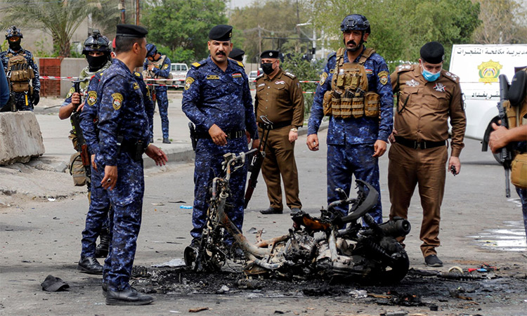 Members of security forces inspect the scene of an explosion in Baghdad. Reuters