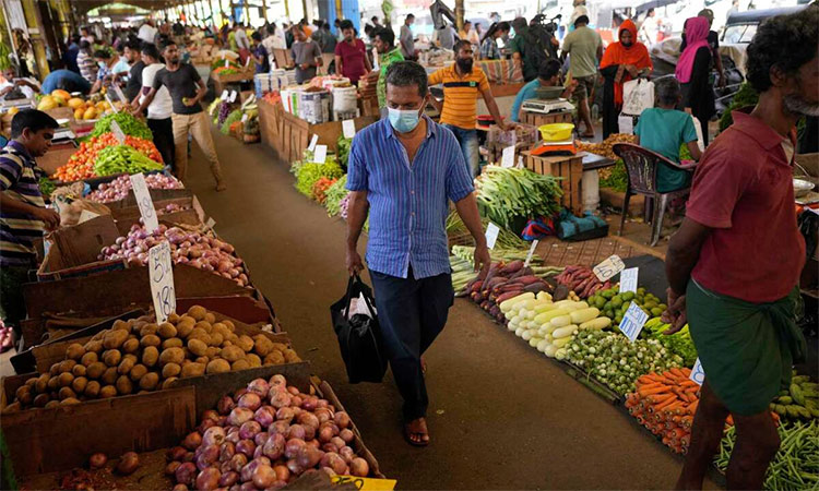 People shop for vegetables at a market in Colombo, Sri Lanka. Country’s economic crisis, the worst in its history, has completely recast the lives of the country's once galloping middle class. AP
