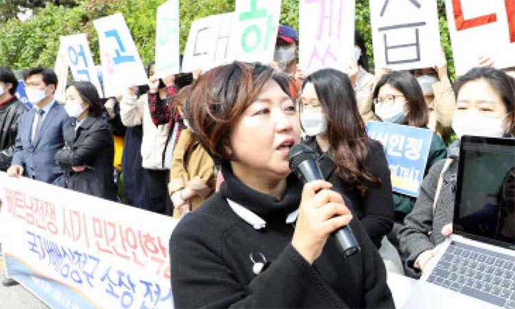 Protesters hold placards demanding compensation for the Korea war survivors.