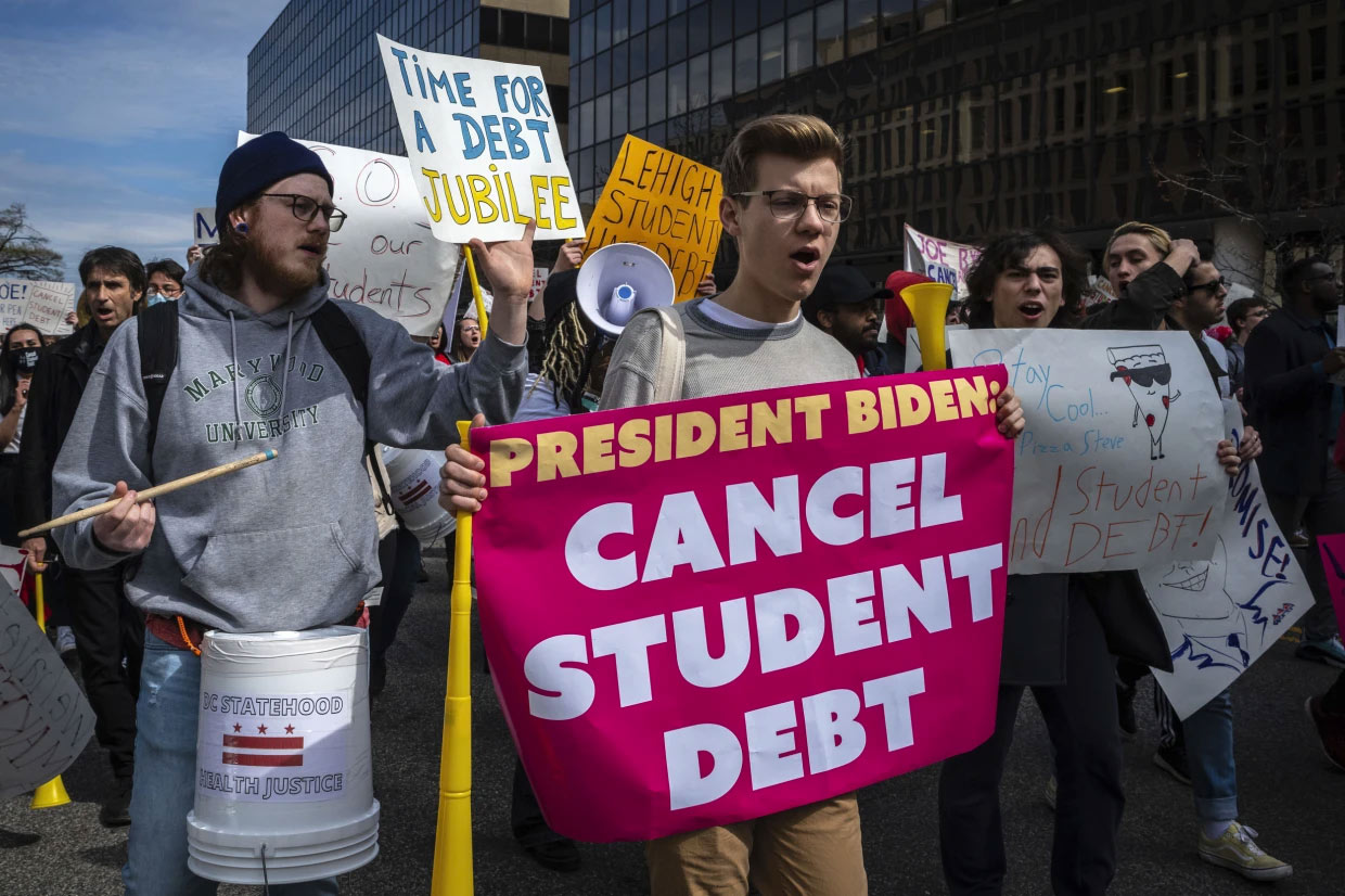 People march against student debt around the Education Department in Washington. AP