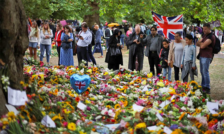 People look at the floral tributes in Green Park, following the death of Britain's Queen Elizabeth, near Buckingham Palace in London. Reuters