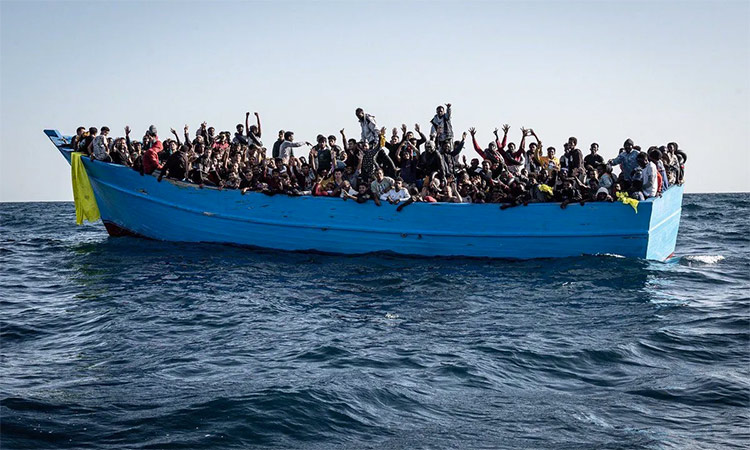 A boat full of passengers sails towards a Syrian seaport.