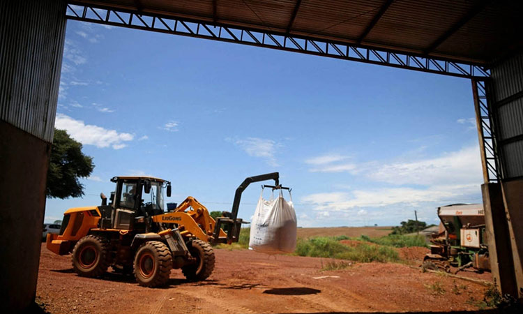 A tractor loads fertilizer before spreading it in a soybean field near Brasilia, Brazil.     Reuters