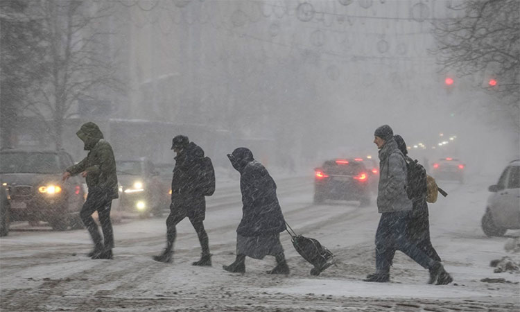 People cross a road amid snowfall in Kyiv, Ukraine. Reuters