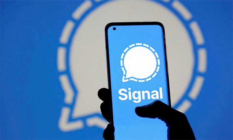 The Signal messaging app logo is seen on a smartphone, in front of the same displayed same logo, in this illustration. File/Reuters